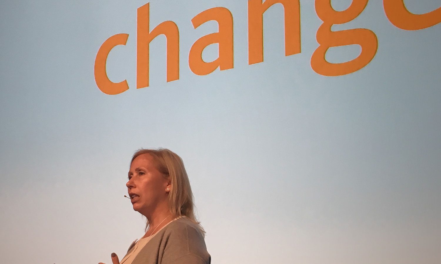 A woman standing in front of a change sign.