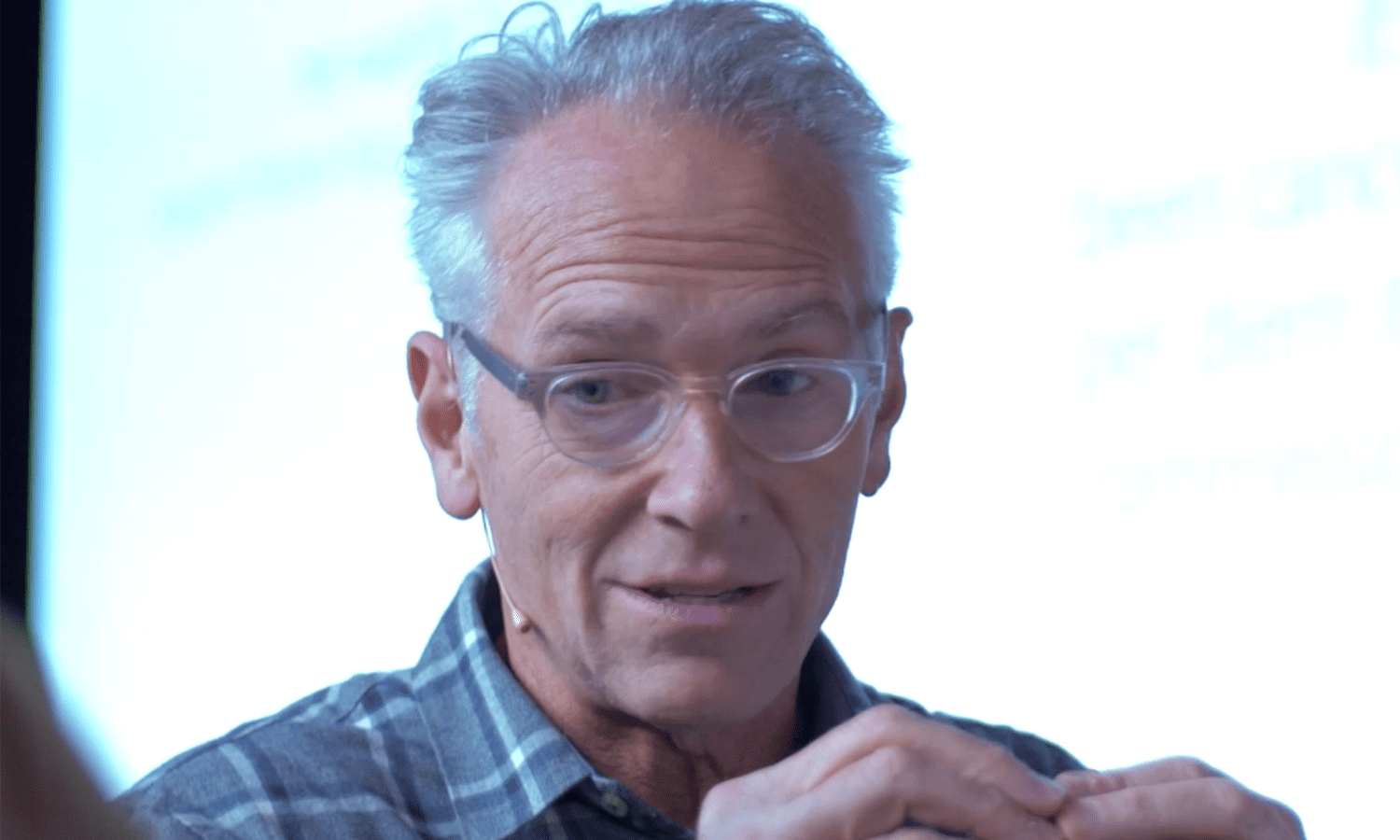 A man with glasses is looking at the camera.